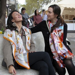 Friends laughting & having fun on an evening date with pure silk scarves by Daba Disseny Barcelona - An elegant Christmas gift